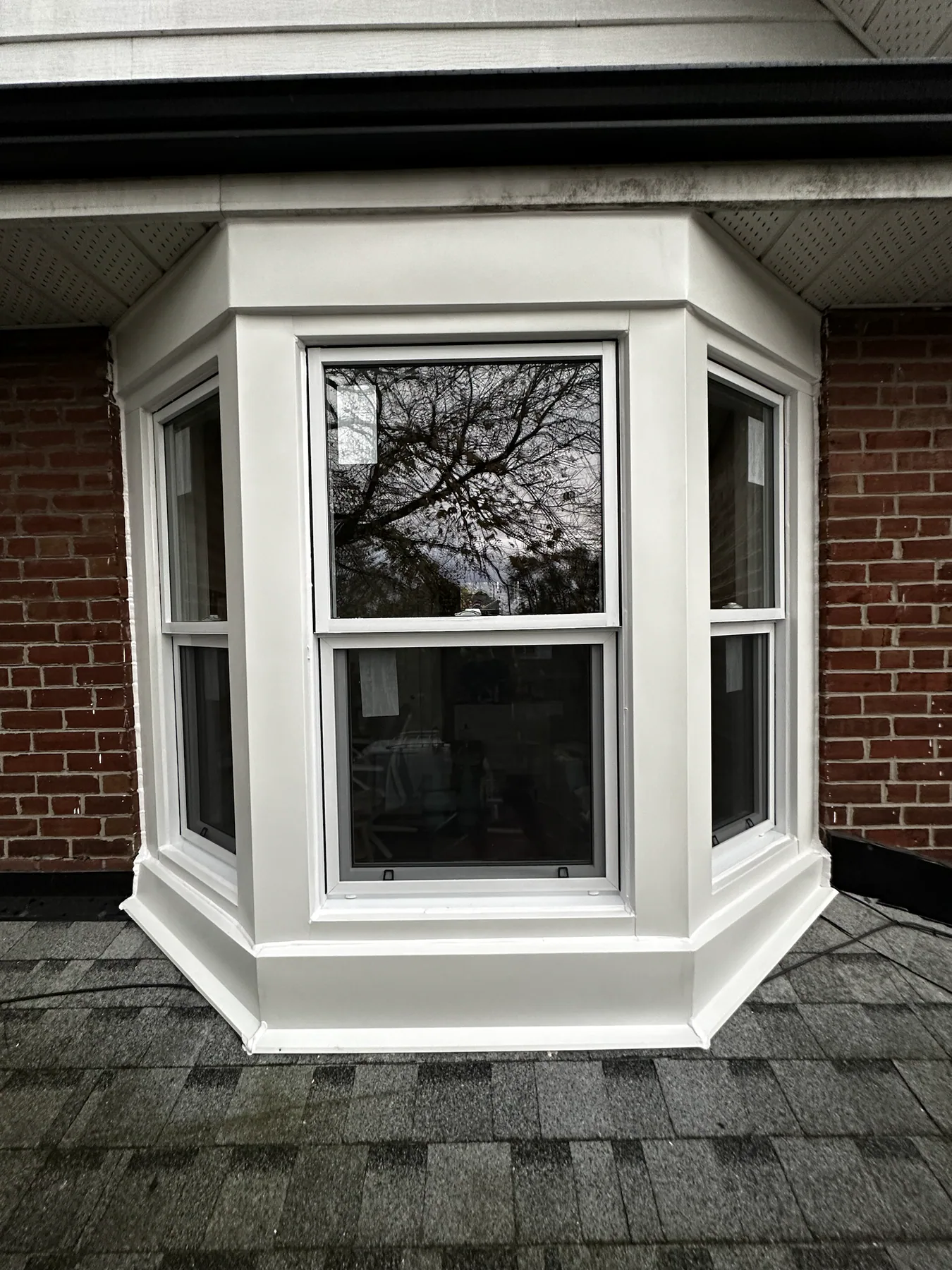 Finished white bay window on a brick semi-detached home