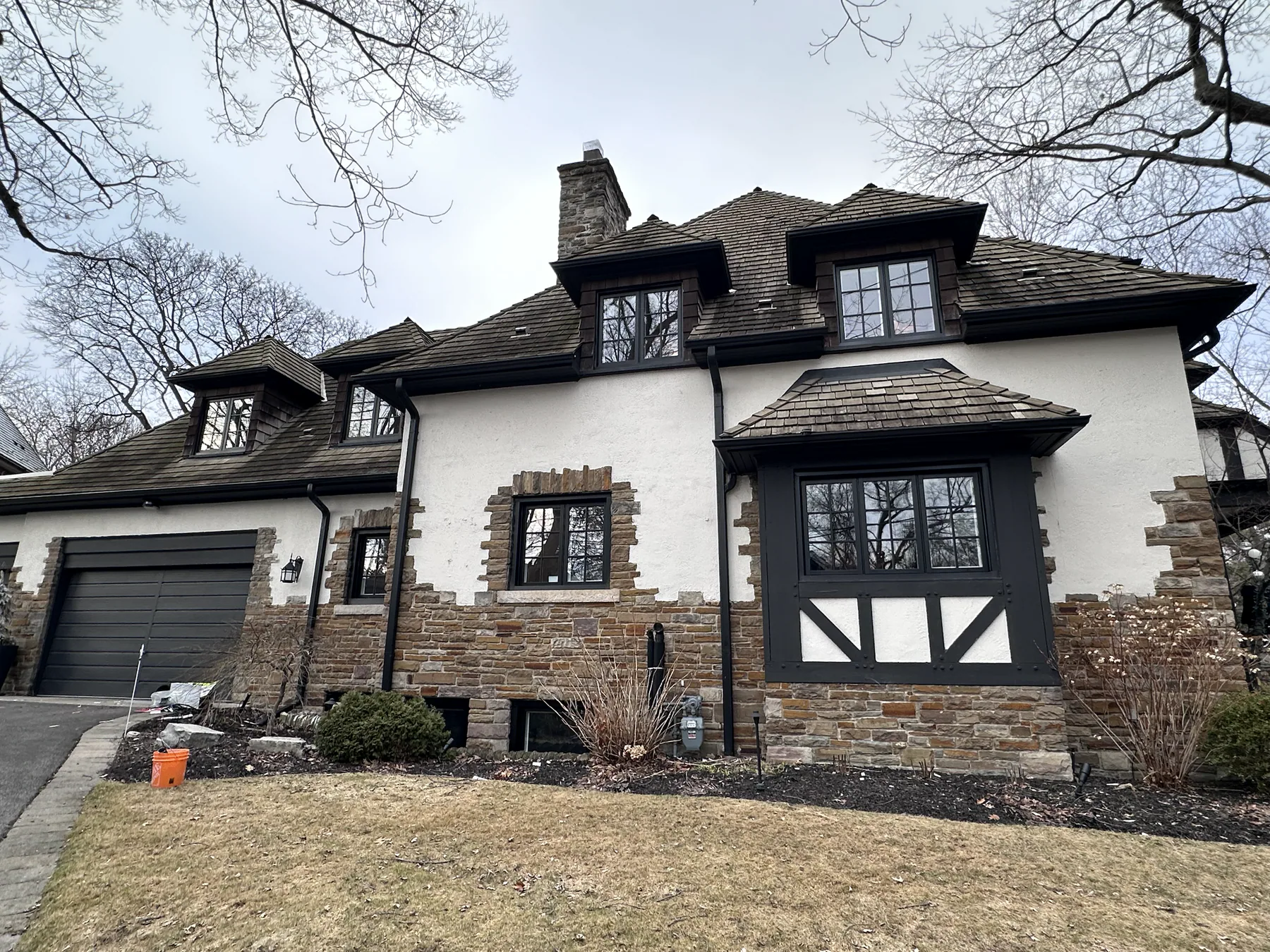 Tudor-style home with newly installed dark-framed windows